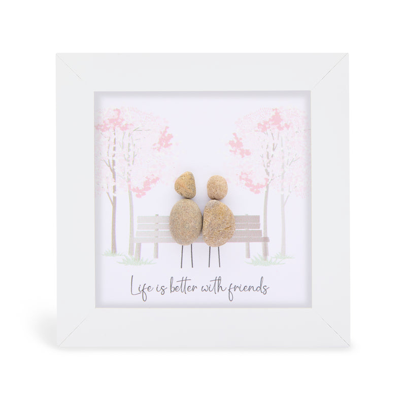 "Life is better with friends" mini plaque, white frame with two pebble figures sitting on a park bench surrounded by soft pink blossom trees
