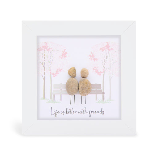 "Life is better with friends" mini plaque, white frame with two pebble figures sitting on a park bench surrounded by soft pink blossom trees