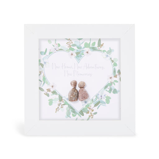 Pebble art framed plaque with two natural pebble figures inside an illustrated heart wreath of soft green foliage, white flowers and butterflies, with the sentiment "New Home, New Adventures, New Memories", white frame