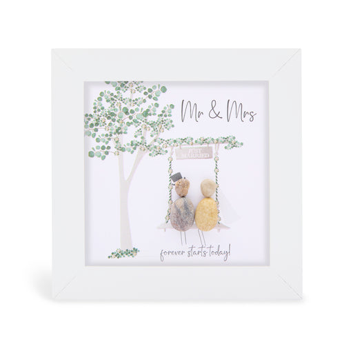 Pebble art framed plaque with two natural pebble figures sitting on a swing beneath a green illustrated tree, one wearing a top hat, a Just Married sign above them, and the sentiments "Mr & Mrs" and "forever starts today!", white frame