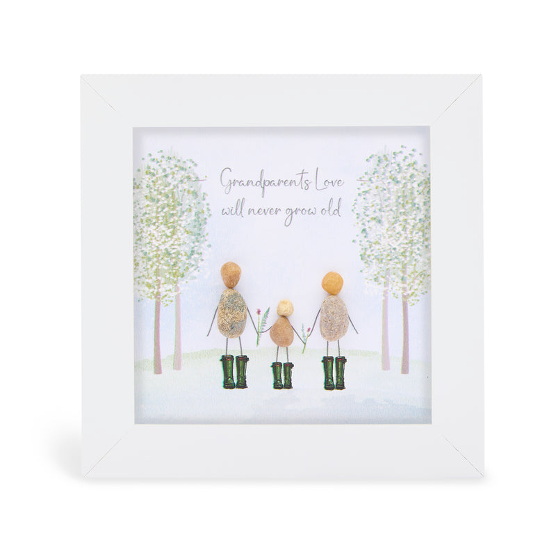 Grandparents Love will never grow old" mini plaque, white frame with pebble figures of two grandparents and a child holding hands in green wellies, illustrated woodland background