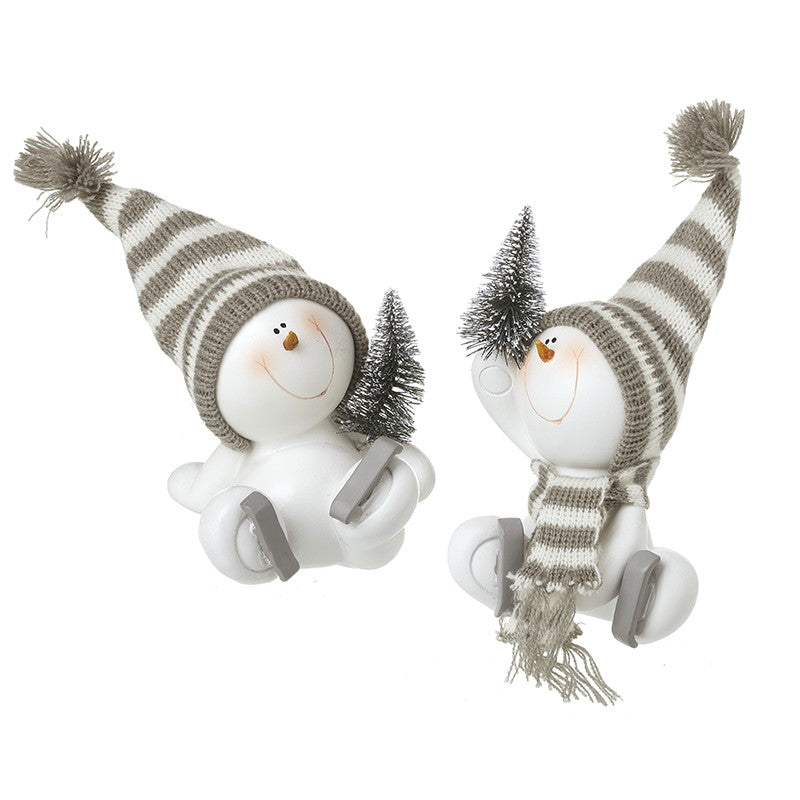 Two sitting skating snowman decorations with grey striped bobble hats, ice skates and miniature Christmas trees, one with knitted scarf
