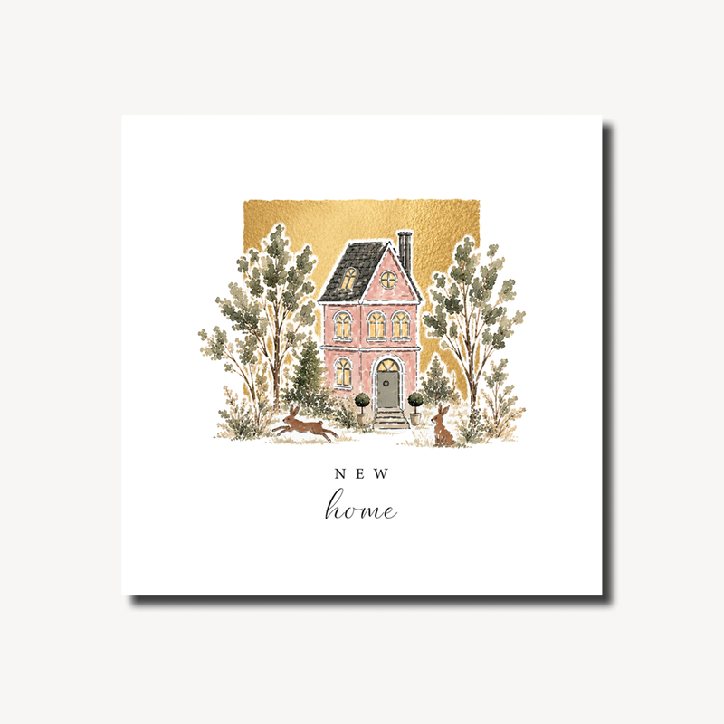 New home card featuring a pink house with glowing windows surrounded by trees and two hares in the garden, warm gold foil background, blank inside, square format 155 x 155mm