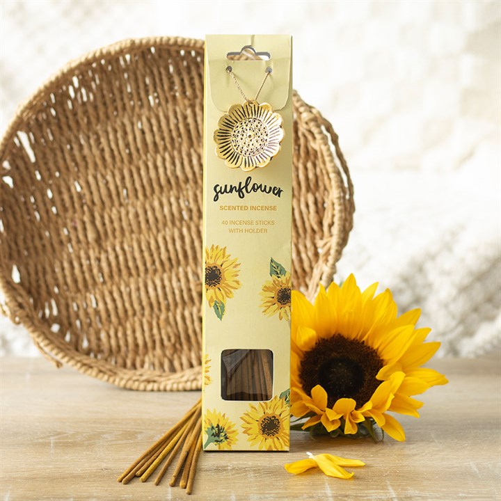 Sunflower Scented Incense Sticks with Holder, lifestyle shot of packaging standing upright with gold-tone sunflower holder attached, fresh sunflower and wicker tray in background