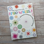 Get Creative with Spiro Wheels activity set box cover showing colourful spirograph-style pattern designs, on a wooden surface