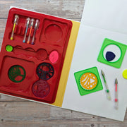 Spiro Wheels activity set contents laid out — red tray with 9 spiro wheels, 2 green square frames, 6 coloured pens and drawing pad