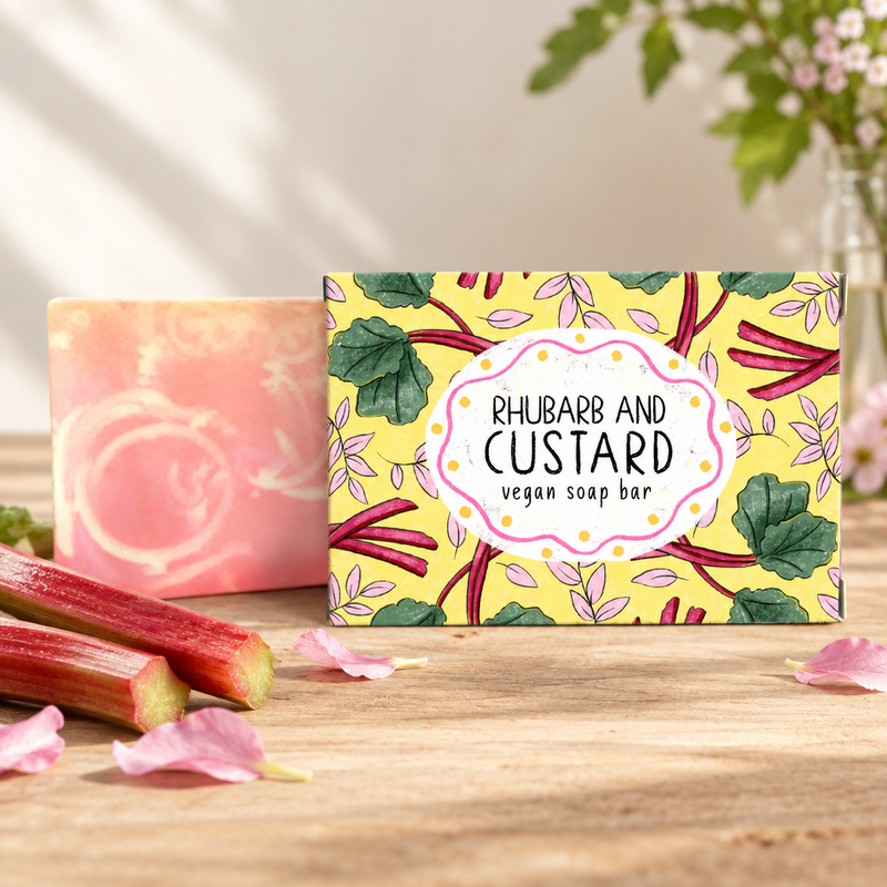 Neon Magpie Rhubarb and Custard Vegan Soap Bar in yellow botanical packaging styled on a wooden surface with fresh rhubarb stalks and pink flower petals