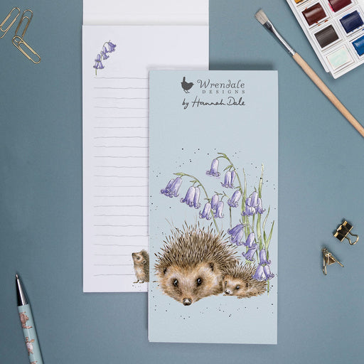 Wrendale Designs Love and Hedgehugs shopping pad on a desk alongside a pen, paperclips and watercolour paints