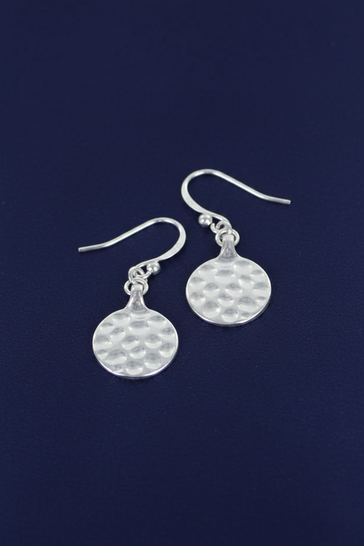 Silver plated disc drop earrings with textured detail and hook fittings on a deep navy blue background
