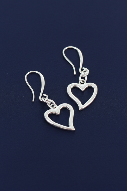 Silver plated open heart charm earrings on short chain with hook fittings on a deep navy blue background