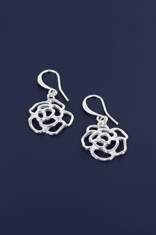 Silver plated open rose charm drop earrings with layered petal detail on hook fittings on a deep navy blue background
