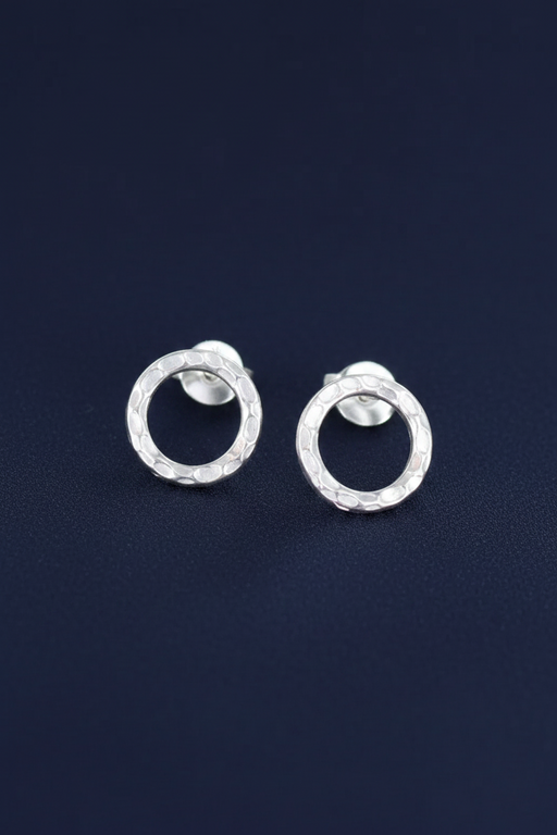 Silver plated open circle stud earrings with butterfly backs on a deep navy blue background