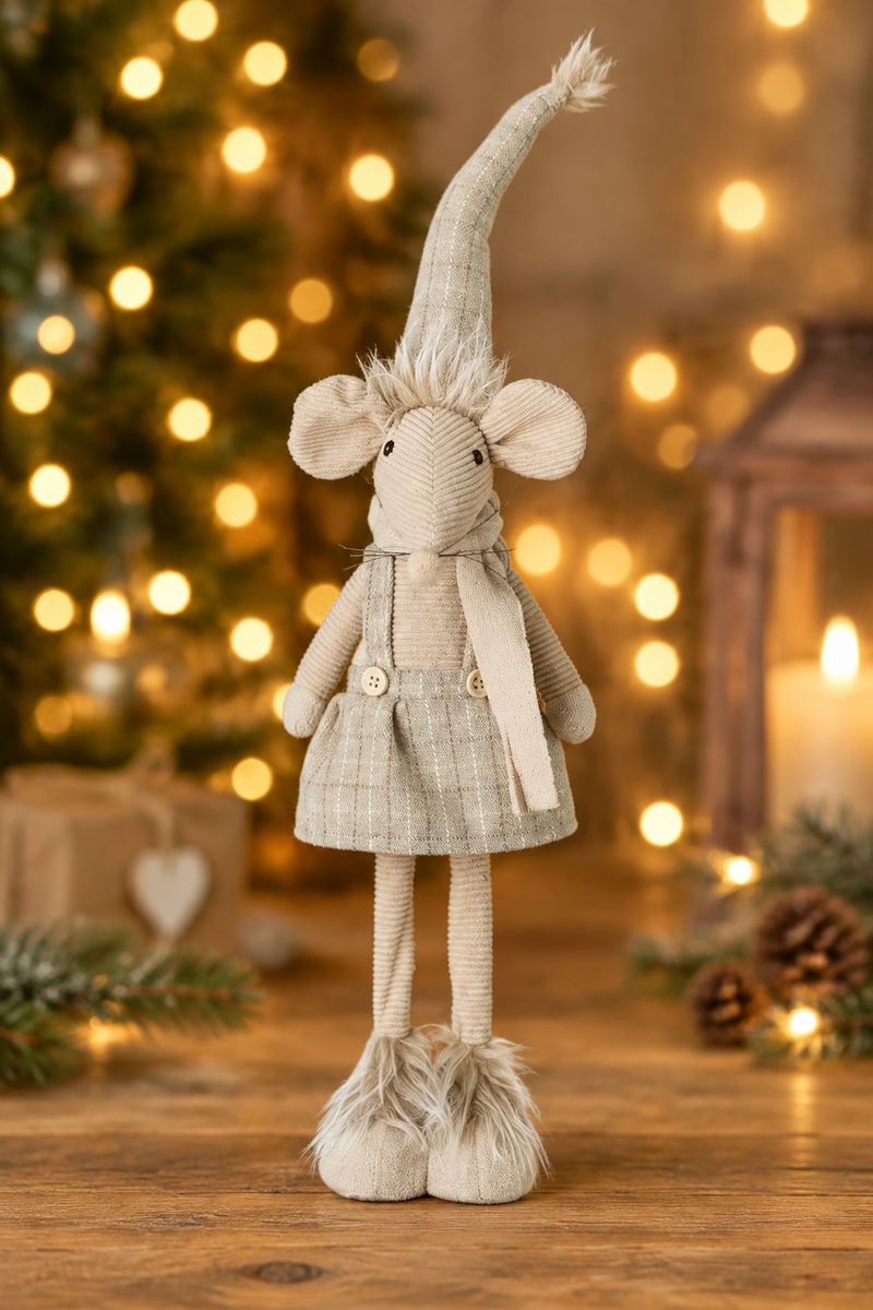 Standing mouse Christmas decoration in dress displayed on a wooden surface with warm golden bokeh fairy lights in the background