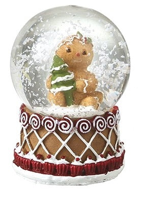 Gingerbread Christmas snow globe featuring a character holding a Christmas tree above a lattice-patterned base.