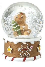 Gingerbread Christmas snow globe featuring a character holding a Christmas tree above a base decorated with stars and a gingerbread figure.