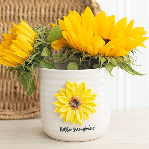 Hello Sunshine Plant Pot with 3D Sunflower, lifestyle shot filled with fresh sunflowers on a white shelf with wicker basket in background