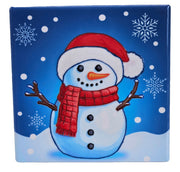 Ceramic Christmas coaster featuring a smiling snowman in a Santa hat and scarf, surrounded by snowflakes and falling snow.
