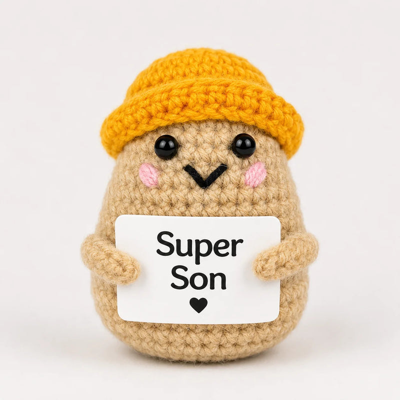Super Son Positive Crochet Gift character wearing a mustard beanie hat and holding a Super Son sign, presented on a white background