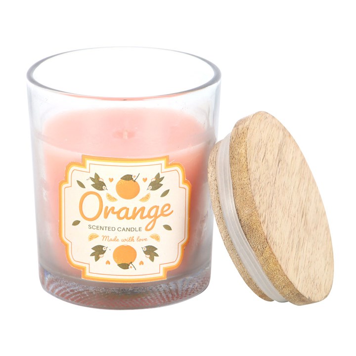 Orange Scented Candle, close-up of clear glass jar with wooden lid removed showing candle wax and orange illustrated label, white background