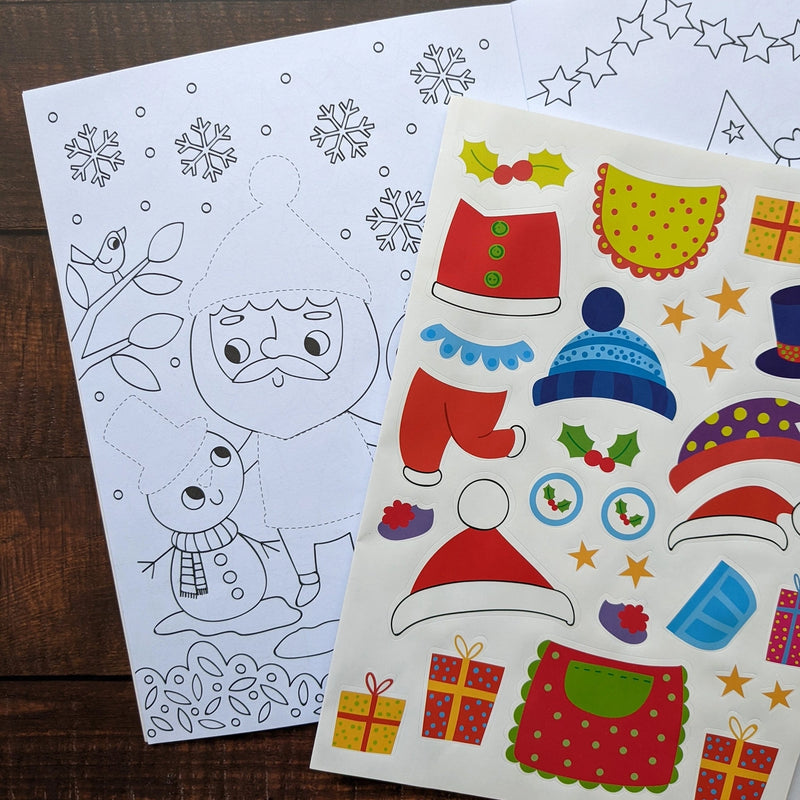 Dress Me Up Santa Colouring and Activity Book, lifestyle shot showing open book with colouring page and sticker sheet on wooden surface