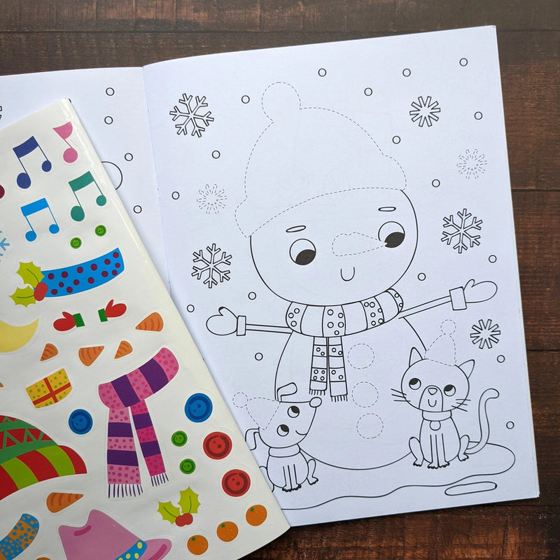Dress Me Up Snowman Colouring and Activity Book, lifestyle shot showing open book with snowman colouring page and colourful sticker sheet on wooden surface
