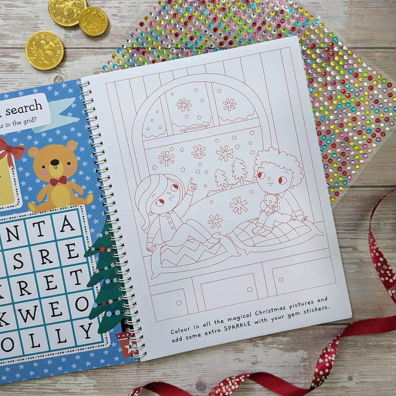 Sparkly Santa Gem Art Activity Book, lifestyle shot showing word search activity on left and children watching snow colouring page on right with gem sticker sheet, wooden surface