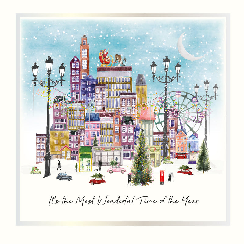 A snowy illustrated cityscape with festive street lamps, Santa on a rooftop, a ferris wheel, Christmas trees, and the sentiment "It's the Most Wonderful Time of the Year" with holographic silver and vintage gold foil detail