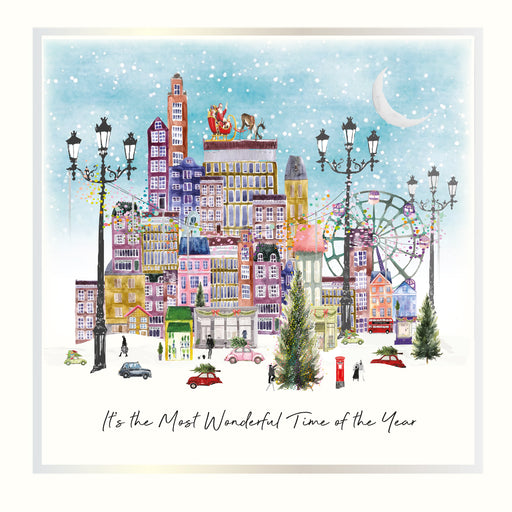 A snowy illustrated cityscape with festive street lamps, Santa on a rooftop, a ferris wheel, Christmas trees, and the sentiment "It's the Most Wonderful Time of the Year" with holographic silver and vintage gold foil detail