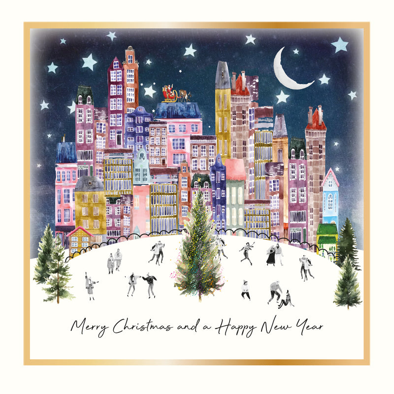 An illustrated Christmas card showing a vibrant colourful cityscape at night with people skating around a Christmas tree, Santa's sleigh on a rooftop, a crescent moon and stars, framed with a gold foil border, with the sentiment "Merry Christmas and a Happy New Year"