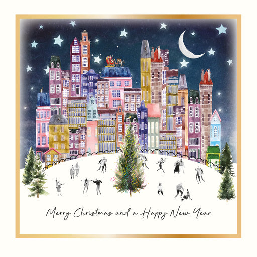 An illustrated Christmas card showing a vibrant colourful cityscape at night with people skating around a Christmas tree, Santa's sleigh on a rooftop, a crescent moon and stars, framed with a gold foil border, with the sentiment "Merry Christmas and a Happy New Year"