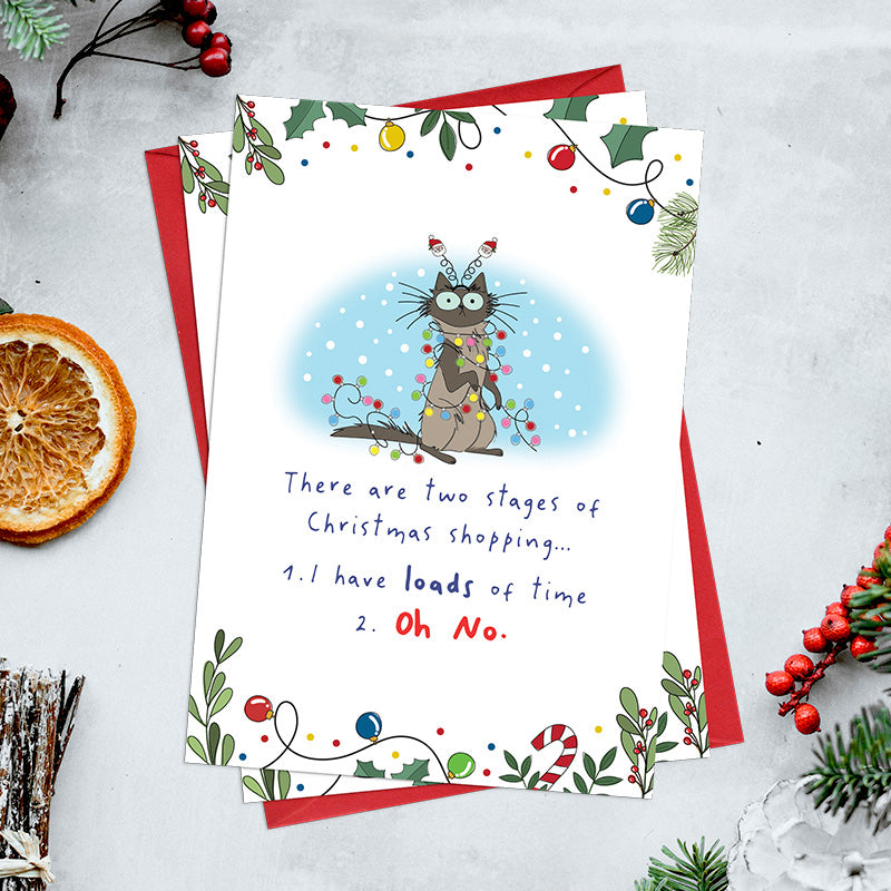 Pack of 6 funny Christmas shopping cards featuring a wide-eyed cat tangled in fairy lights, with the message about having loads of time followed by ‘Oh No