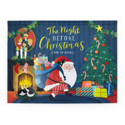 The Night Before Christmas Pop-Up Book front cover on a white background, showing Santa carrying a gift sack beside a decorated Christmas tree with a sleeping cat by the fireplace