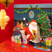 The Night Before Christmas Pop-Up Book open spread showing Santa delivering gifts beside a decorated Christmas tree with pop-up 3D scene