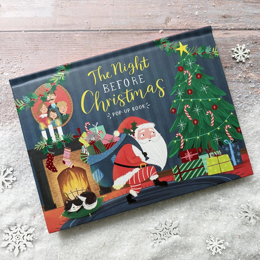 The Night Before Christmas Pop-Up Book lying flat on a snowy surface showing the illustrated front cover