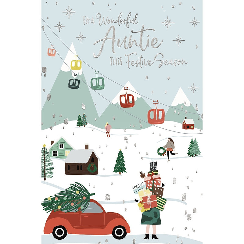 Wonderful Auntie Christmas card featuring a snowy mountain village with cable cars, a car carrying a Christmas tree and a woman holding a stack of presents.