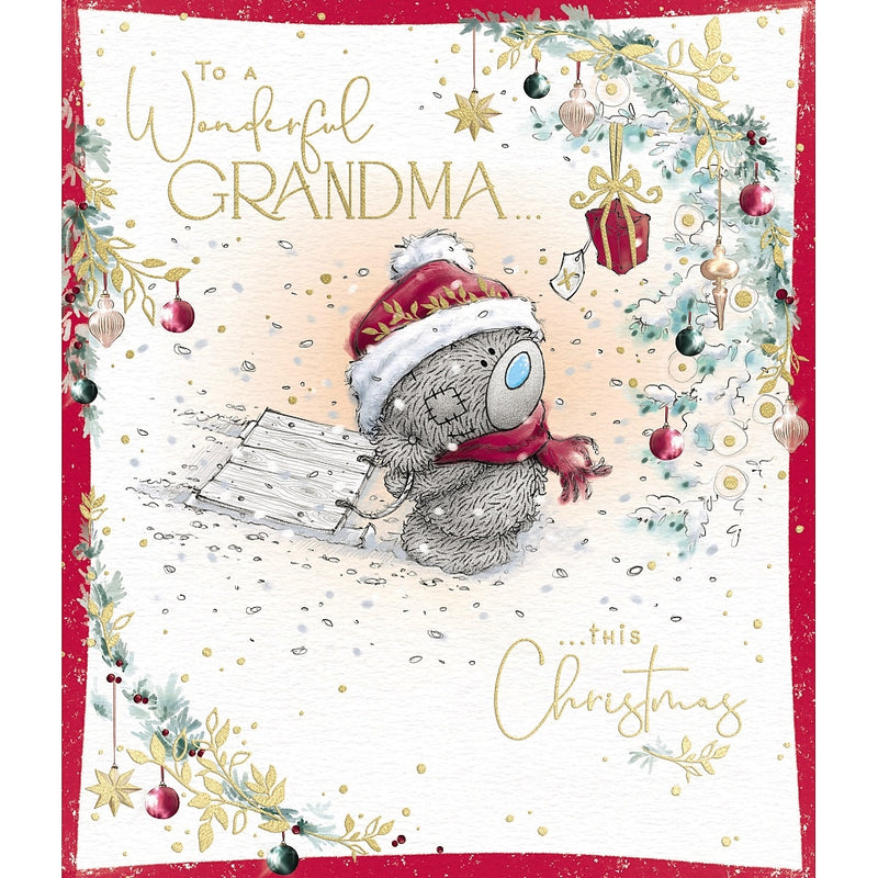 Wonderful Grandma Tatty Teddy Christmas card featuring a bear wearing a Santa hat and scarf, pulling a sledge through snow beside a decorated Christmas tree, framed by festive foliage and baubles