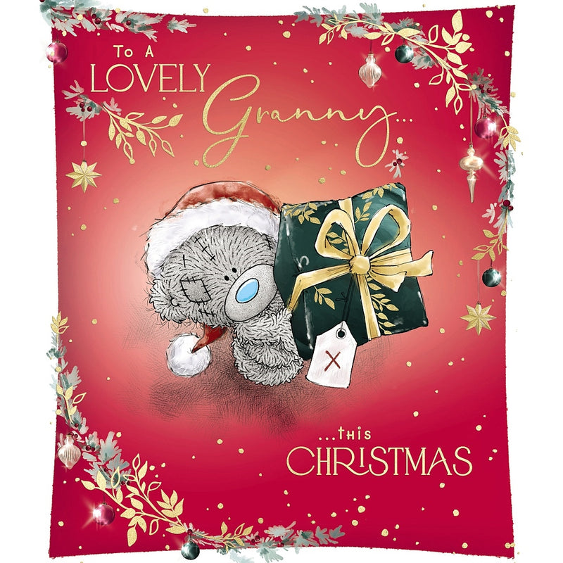 Lovely Granny Christmas card featuring Tatty Teddy in a Santa hat holding up a wrapped present tied with a bow, framed by festive foliage, hanging baubles and stars.