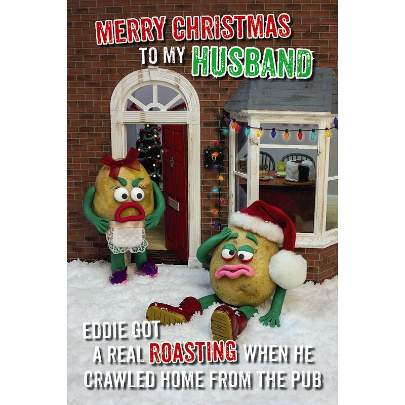 Funny Husband Christmas card featuring two potato characters outside a house decorated for Christmas, one sitting in the snow wearing a Santa hat and the other standing by the doorway.