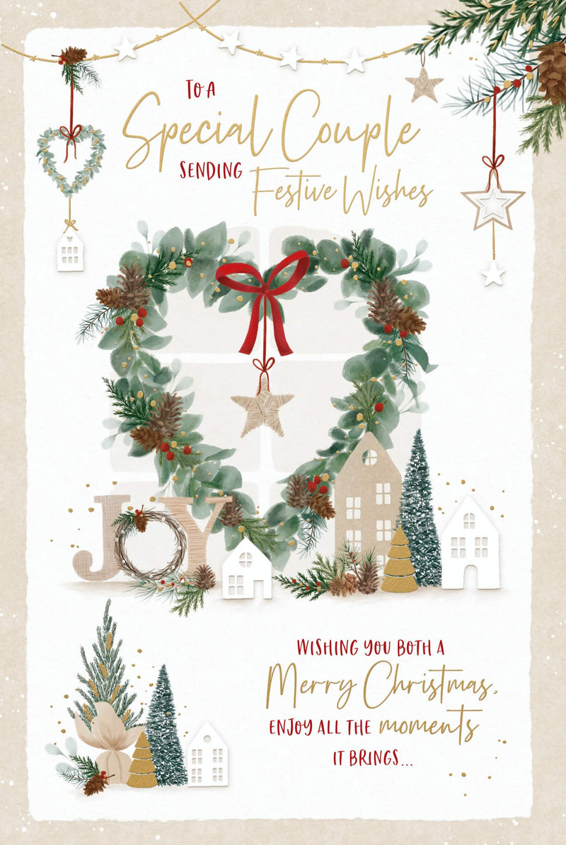 Special Couple Christmas card featuring a heart-shaped foliage wreath with pinecones, berries, a ribbon bow and hanging star, alongside little houses, Christmas trees and JOY lettering.