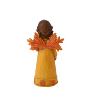 Country Living autumn fairy figurine small, rear view showing warm orange-toned leaf wings and detailed brown wavy hair, mustard yellow dress, white background