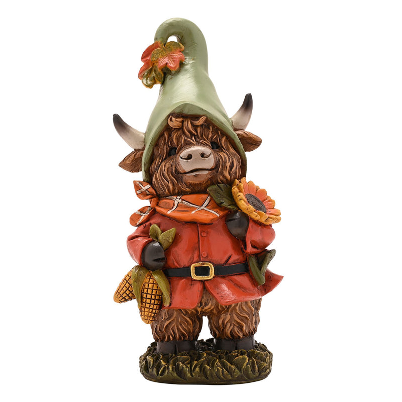 Highland cow autumn figurine, front view showing sage green pointed hat with autumn leaves, terracotta coat, orange tartan scarf, holding sunflower and corn cobs, white background