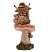 Highland cow on mushroom figurine, rear view showing shaggy fur and tartan scarf detail, rust-coloured toadstool, white background