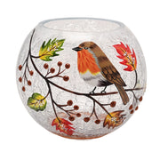 A round crackle glass votive holder with a hand-painted robin perched on a berry branch with autumn leaves and berries, unlit, front view on a white background