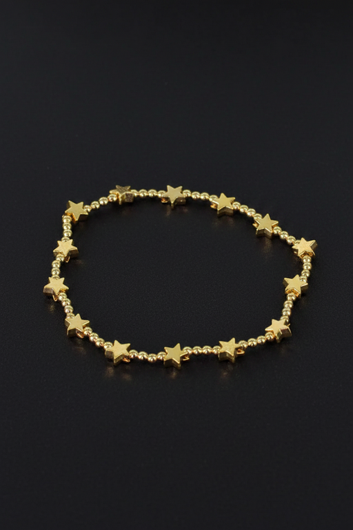 18ct gold plated elasticated bracelet with alternating round beads and flat star beads on a black background