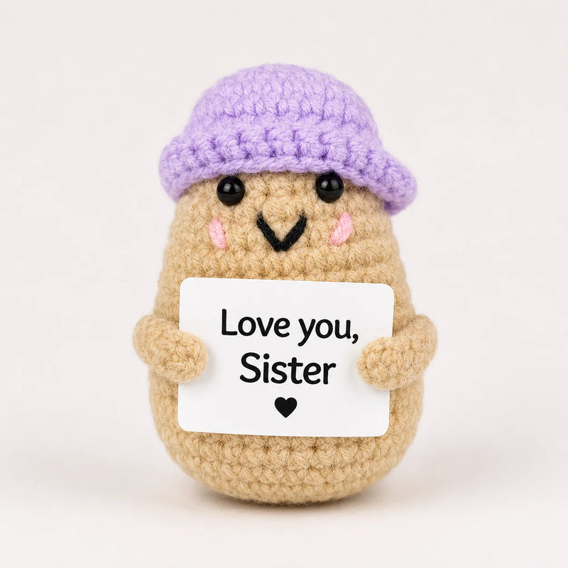 Love You Sister Positive Crochet Gift character wearing a lilac beanie hat and holding a Love you Sister sign, presented on a white background