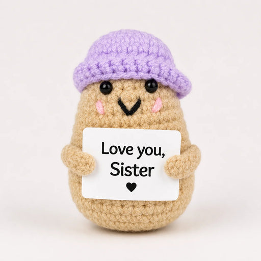 Love You Sister Positive Crochet Gift character wearing a lilac beanie hat and holding a Love you Sister sign, presented on a white background