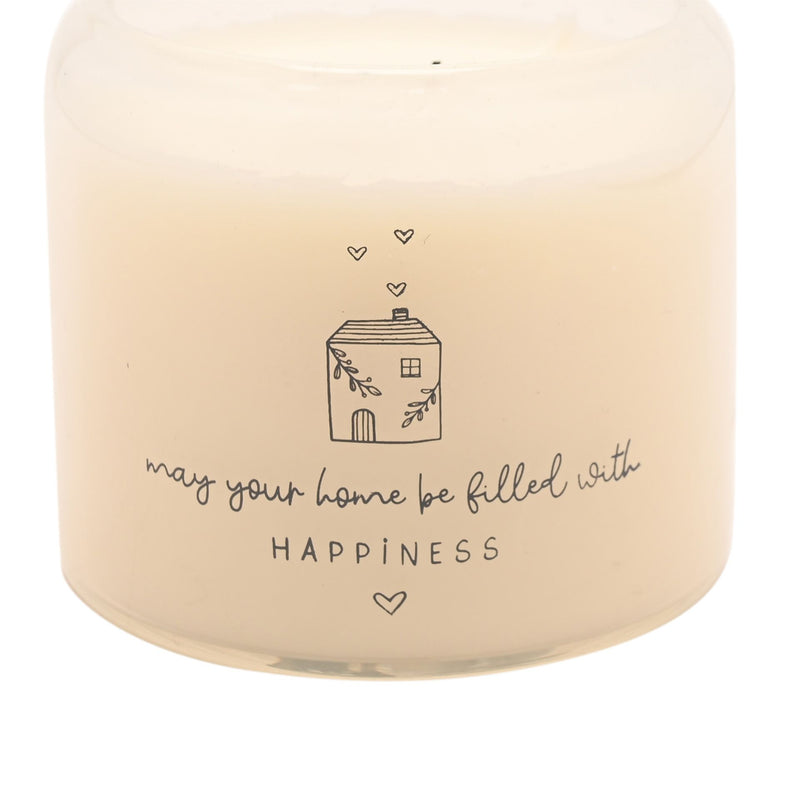 Moments Happy Home candle close-up of illustrated cottage with floating hearts and happiness sentiment