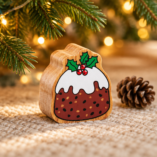 Wooden Christmas pudding toy beside a pinecone beneath Christmas tree branches with warm fairy lights