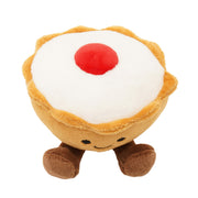 Top-down view of a soft plush Bakewell tart toy with a golden pastry case, smooth white icing top and a fluffy red cherry in the centre, on a white background