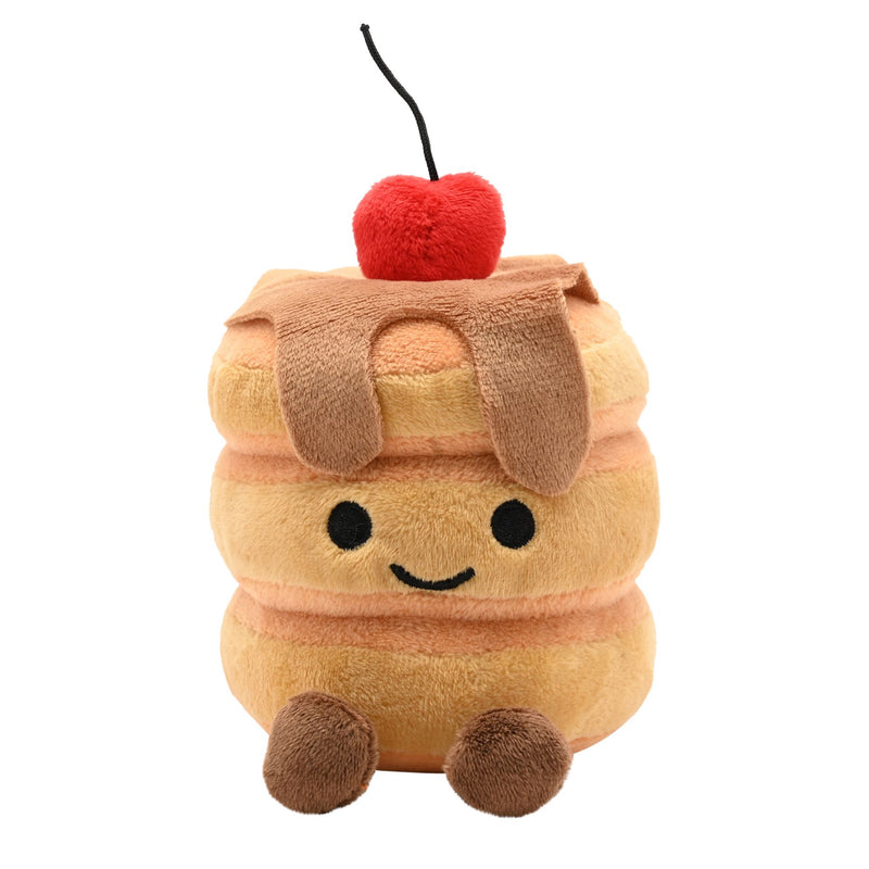 Front view of a soft plush pancake stack toy with three golden pancakes, syrup drizzle, a smiling face, fluffy red cherry on top and fluffy brown feet, on a white background
